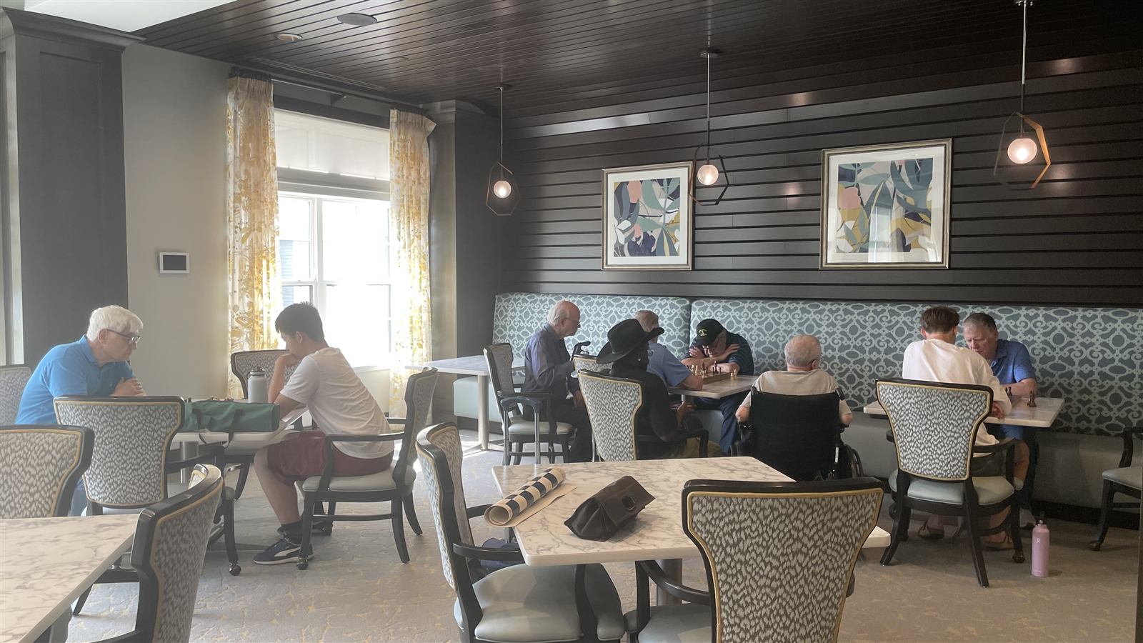 A student volunteer playing chess with a resident at a retirement community